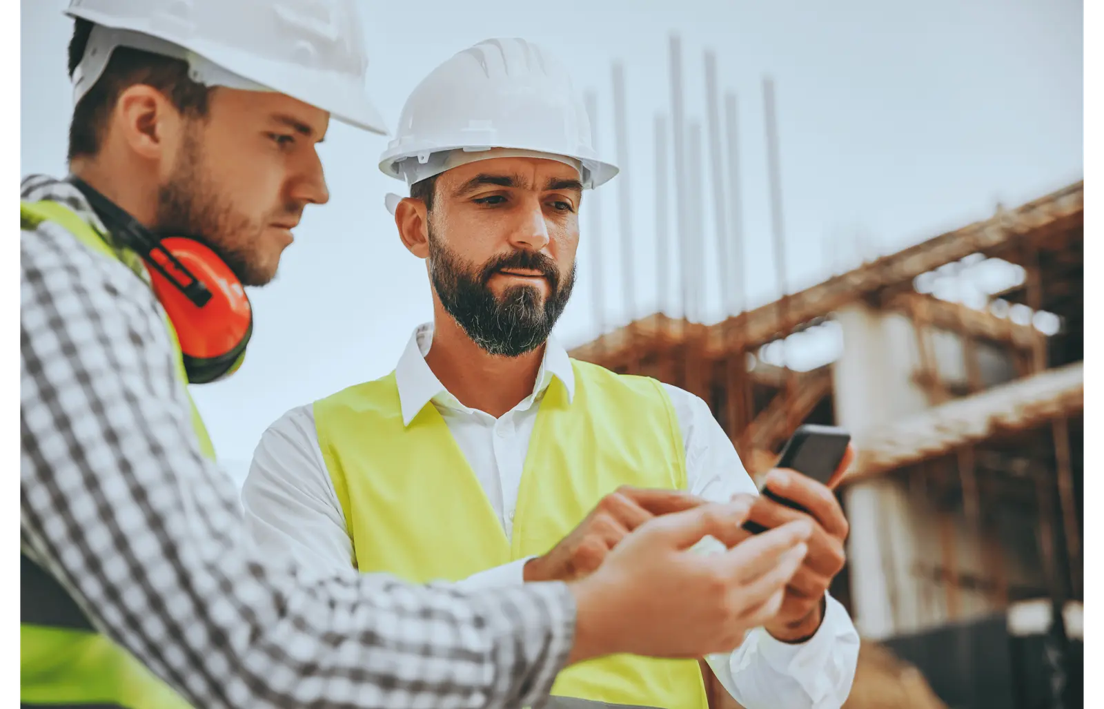 Construction coworkers looking at a phone together
