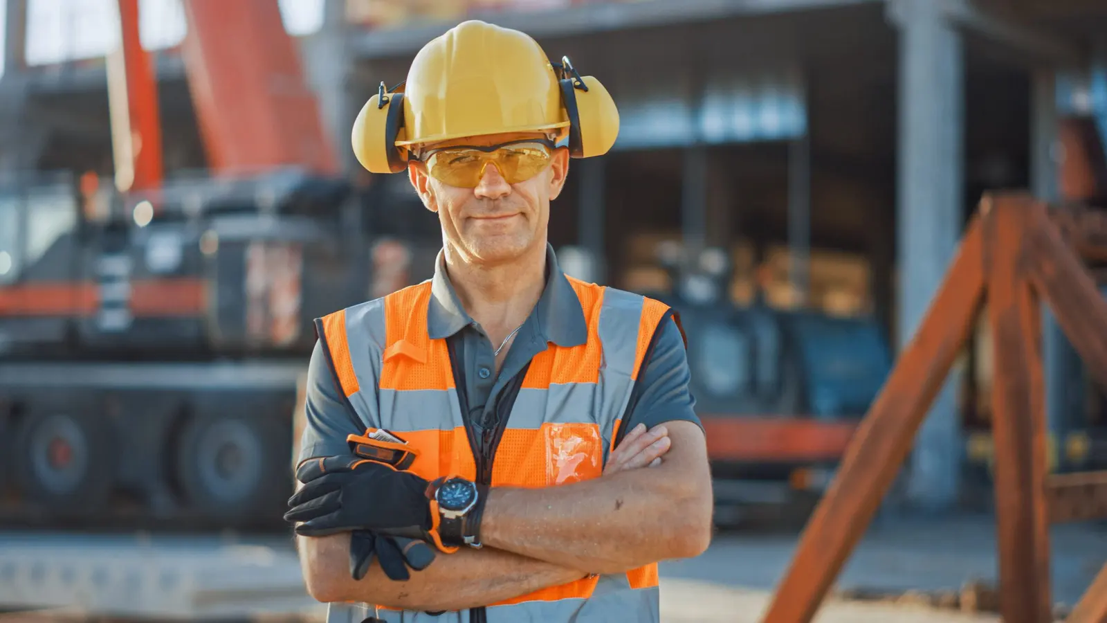 Construction foreman in a safety vest and hard hat on a job site